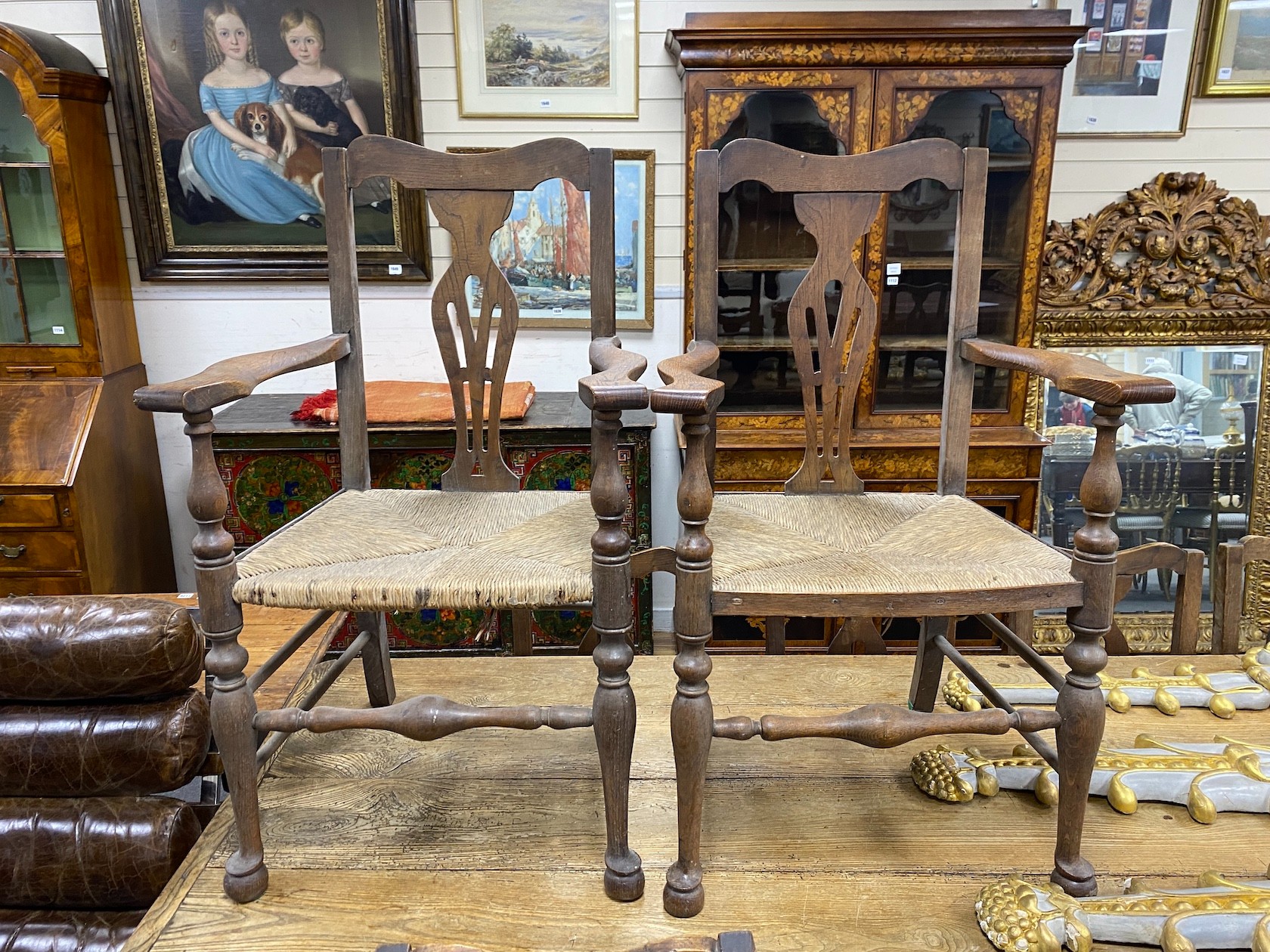 A 19th century elm plank topped kitchen dining table, on a beech underframe, the top, length 275cm, width 92cm, height 76cm, together with a set of ten oak and ask rush seated dining chairs (2 arm, 8 single)